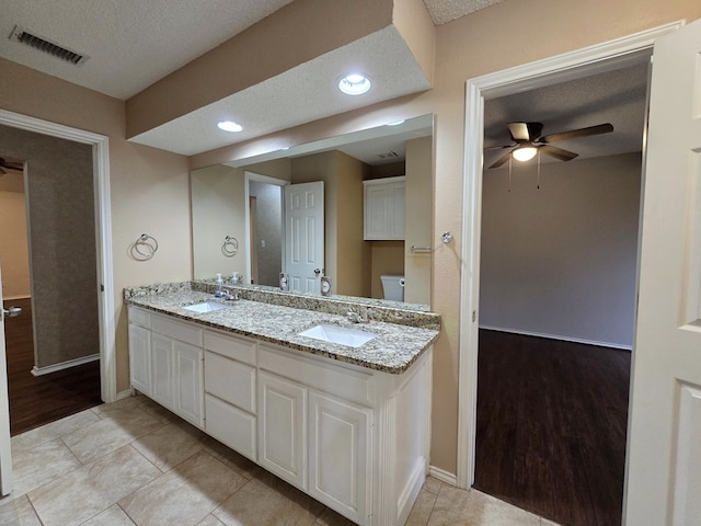 4908 Timber Ct, Midland, TX 79707 - full bath featuring a ceiling fan, a textured ceiling, toilet, baseboards, and double vanity