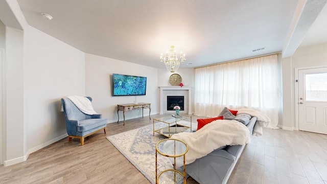 7009 Mcpherson Ln, Midland, TX 79706 - living room featuring light wood-type flooring, a chandelier, baseboards, and a fireplace