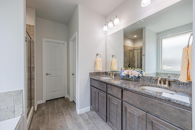 7009 Mcpherson Ln, Midland, TX 79706 - full bathroom featuring a stall shower, double vanity, and wood finished floors