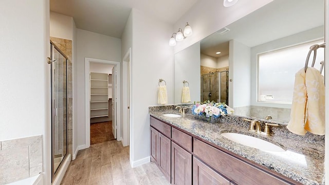 7009 Mcpherson Ln, Midland, TX 79706 - full bath with a shower stall, wood finished floors, double vanity, and a walk in closet