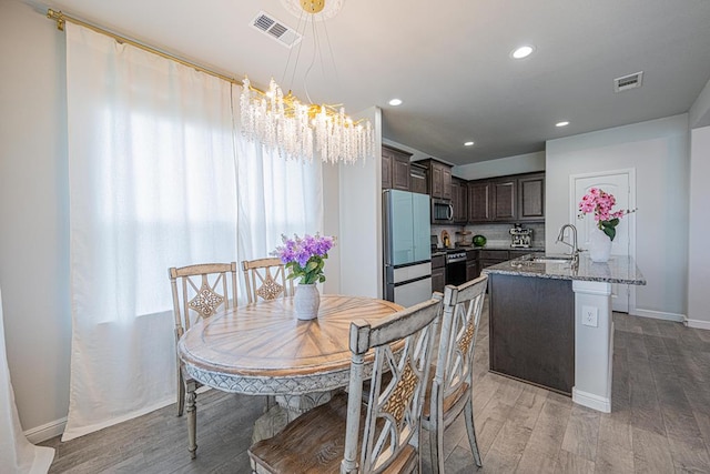 7009 Mcpherson Ln, Midland, TX 79706 - dining room featuring a chandelier, light wood finished floors, baseboards, and recessed lighting