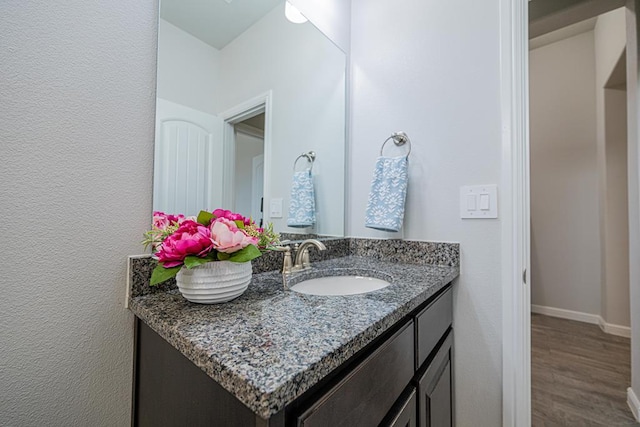 7009 Mcpherson Ln, Midland, TX 79706 - bathroom featuring vanity, wood finished floors, and baseboards