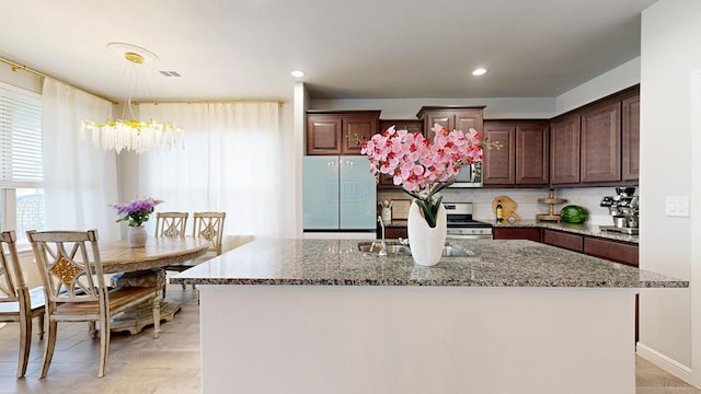 7009 Mcpherson Ln, Midland, TX 79706 - kitchen with appliances with stainless steel finishes, stone counters, a kitchen island, a chandelier, and recessed lighting