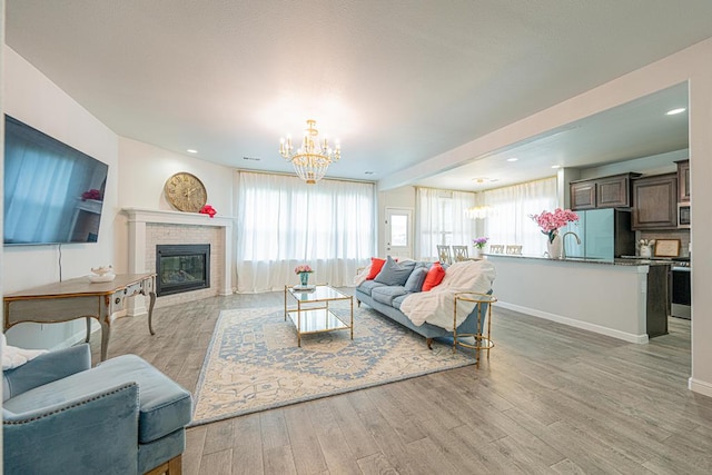 7009 Mcpherson Ln, Midland, TX 79706 - living area featuring a chandelier, light wood-type flooring, plenty of natural light, a fireplace, and recessed lighting