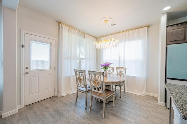 7009 Mcpherson Ln, Midland, TX 79706 - dining room featuring plenty of natural light, light wood finished floors, a chandelier, and baseboards