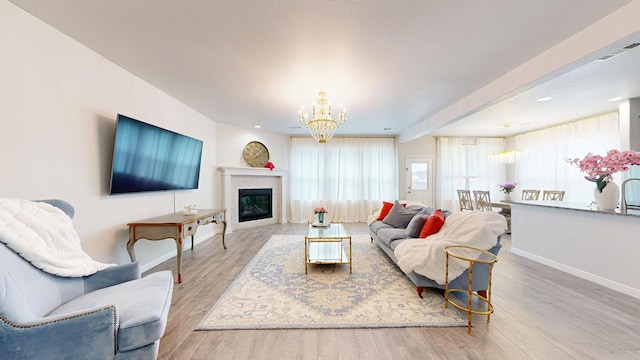 7009 Mcpherson Ln, Midland, TX 79706 - living room featuring a chandelier, baseboards, wood finished floors, and a glass covered fireplace