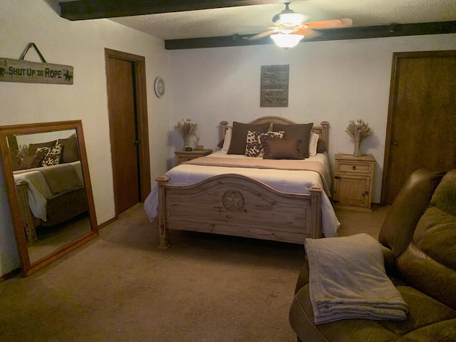 bedroom featuring beamed ceiling, a ceiling fan, and light colored carpet