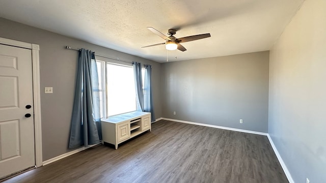 interior space featuring dark hardwood / wood-style flooring, a textured ceiling, and ceiling fan