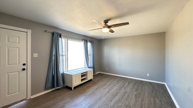 unfurnished room with ceiling fan, dark hardwood / wood-style flooring, and a textured ceiling