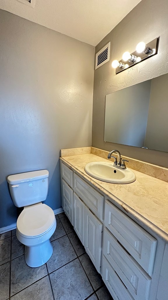 bathroom with vanity, tile patterned floors, and toilet