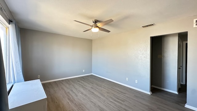 unfurnished room featuring dark hardwood / wood-style flooring, a textured ceiling, and ceiling fan