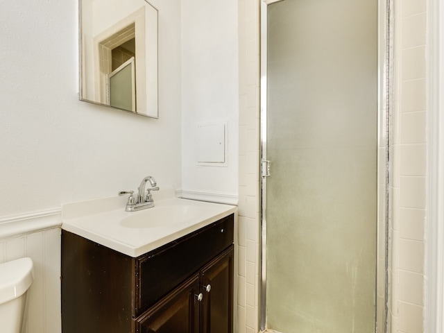 bathroom featuring vanity, toilet, and an enclosed shower