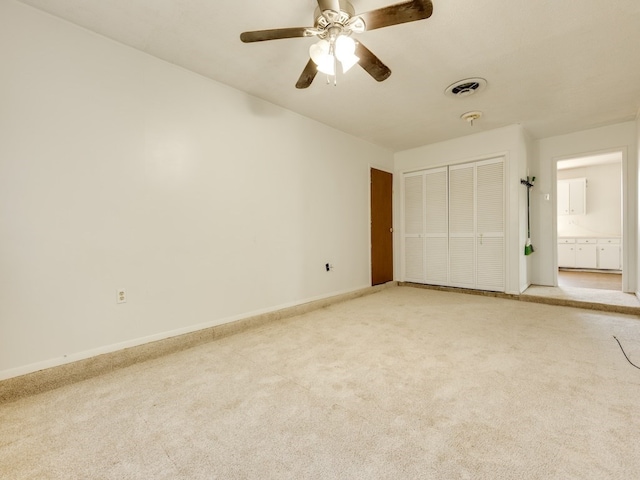 unfurnished bedroom featuring ceiling fan, light colored carpet, and a closet