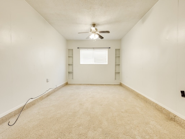 carpeted empty room featuring ceiling fan and a textured ceiling