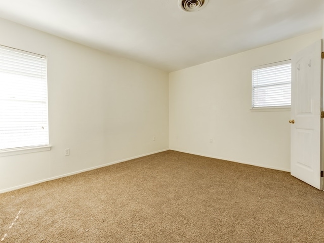 empty room with a healthy amount of sunlight and carpet