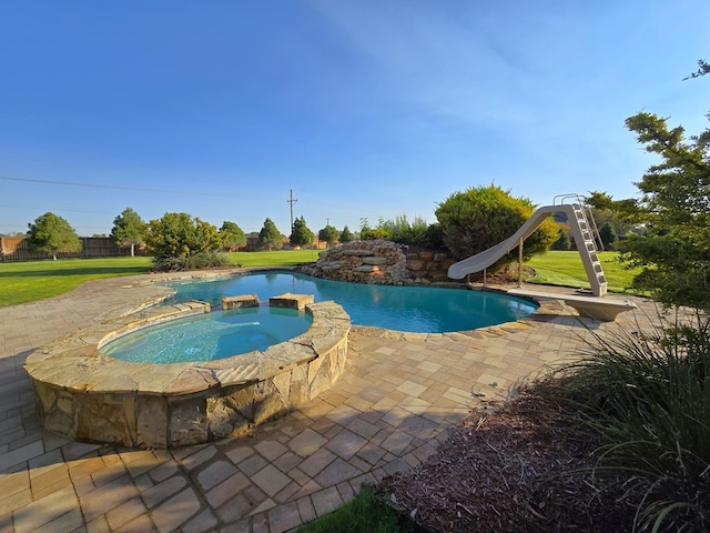 view of pool with an in ground hot tub, a yard, and a water slide