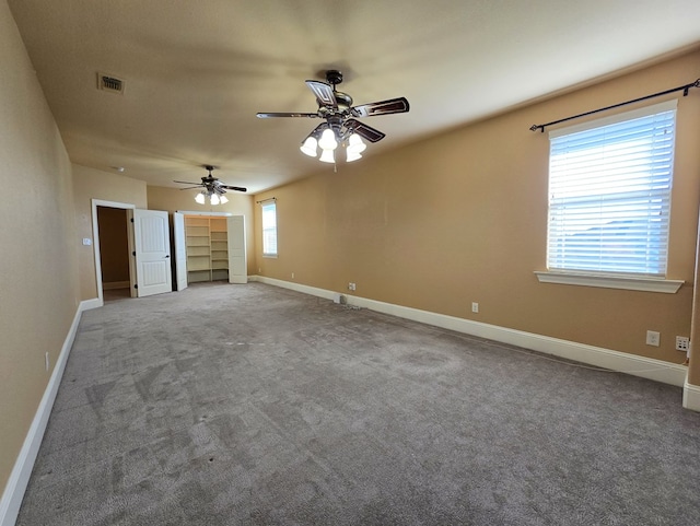 interior space with a ceiling fan, visible vents, and baseboards