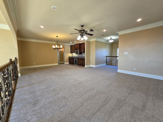 unfurnished living room featuring light colored carpet, ceiling fan with notable chandelier, and ornamental molding