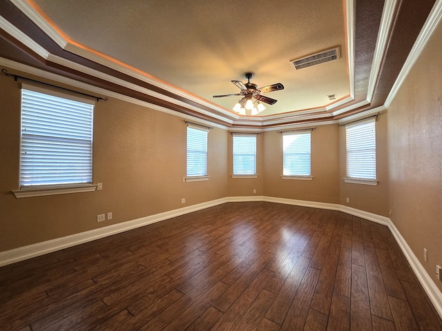 unfurnished room featuring ceiling fan, a raised ceiling, ornamental molding, and dark wood-type flooring