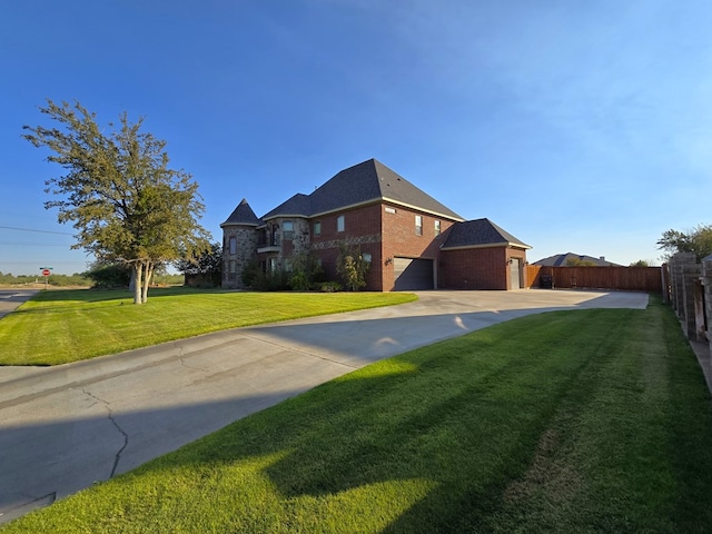 view of front of property with a front lawn, driveway, brick siding, and fence