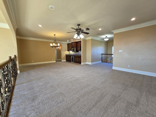 kitchen featuring stainless steel microwave, dark brown cabinetry, light colored carpet, and beverage cooler
