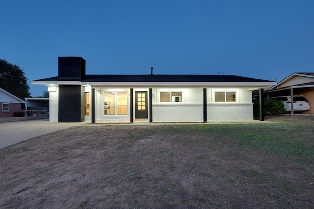 view of front of property featuring brick siding and a chimney