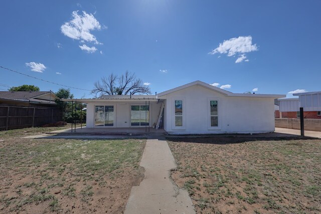 rear view of house with a patio and stucco siding