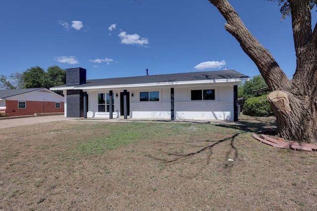 ranch-style home featuring brick siding and a front yard