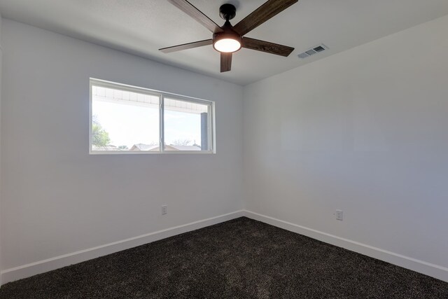 unfurnished room featuring ceiling fan, baseboards, and dark carpet