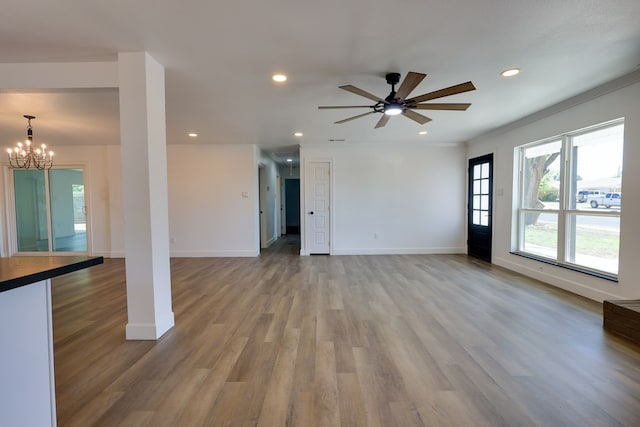 unfurnished living room with a chandelier, recessed lighting, light wood finished floors, a ceiling fan, and baseboards