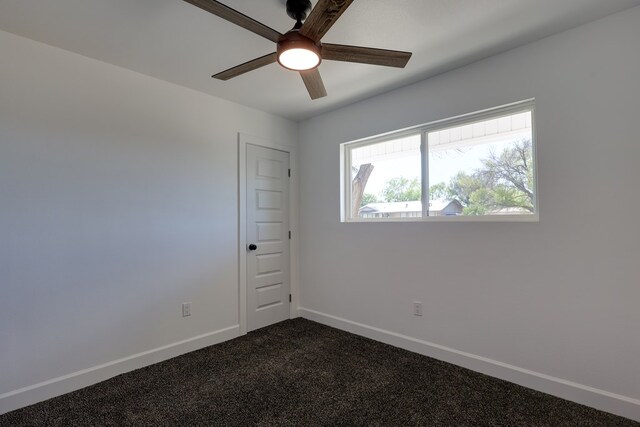 empty room featuring ceiling fan, baseboards, and dark carpet