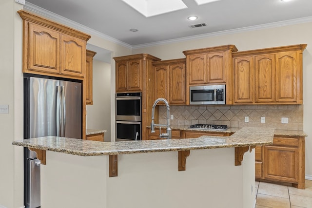 4906 Crista Ln, Midland, TX 79707 - kitchen featuring stainless steel appliances, a breakfast bar area, light stone countertops, crown molding, and recessed lighting