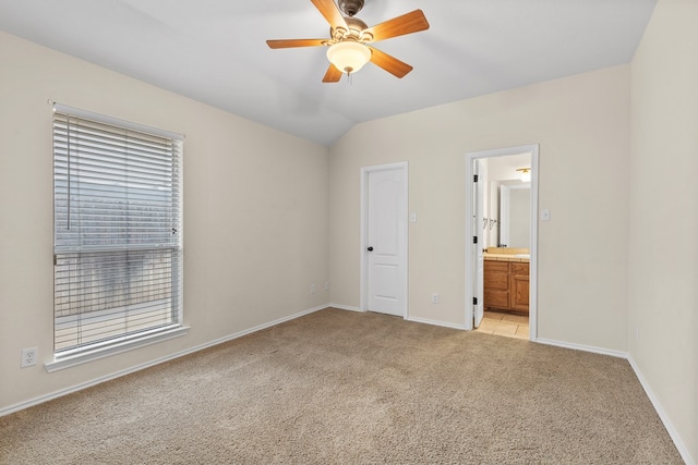 4906 Crista Ln, Midland, TX 79707 - unfurnished bedroom featuring light carpet, connected bathroom, multiple windows, vaulted ceiling, and a ceiling fan
