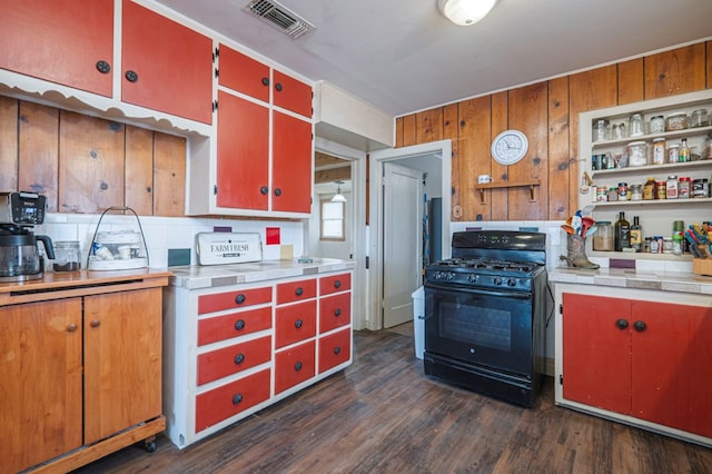 kitchen with black gas range, open shelves, red cabinets, and light countertops