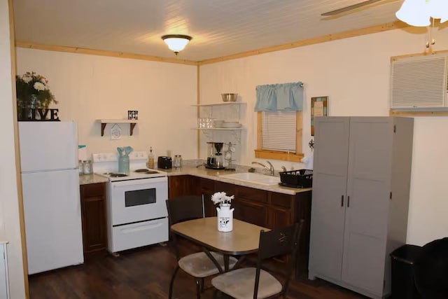 kitchen featuring dark wood finished floors, dark brown cabinetry, light countertops, white appliances, and a sink