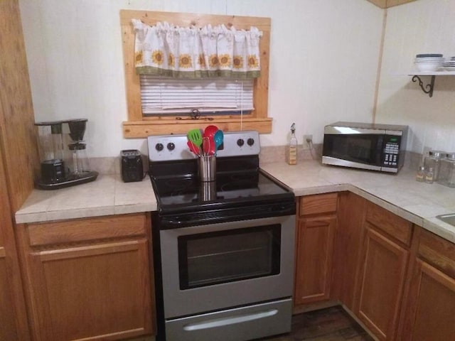 kitchen featuring brown cabinets, appliances with stainless steel finishes, and light countertops