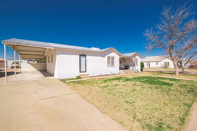 view of front of house featuring stucco siding, driveway, entry steps, a front yard, and an attached carport