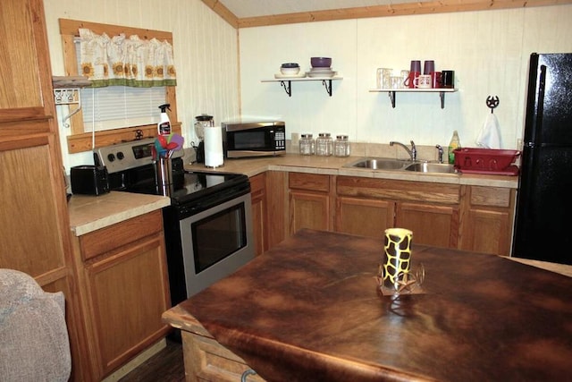 kitchen featuring a sink, stainless steel range with electric stovetop, freestanding refrigerator, brown cabinetry, and open shelves