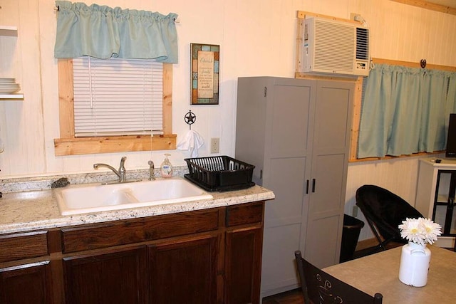 kitchen featuring dark brown cabinetry, light countertops, and a sink