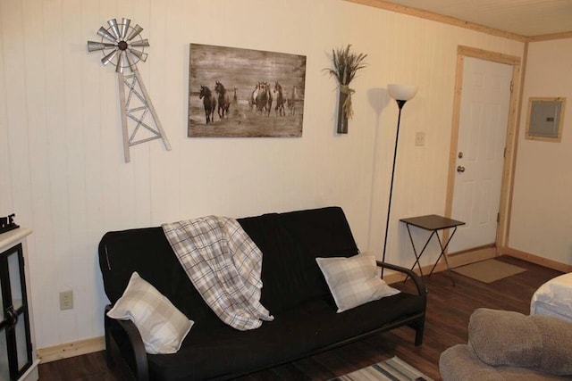 living area with electric panel, baseboards, and wood finished floors