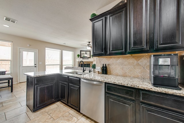 kitchen with visible vents, dishwasher, backsplash, a peninsula, and a sink