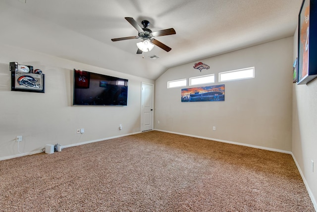 interior space with ceiling fan, lofted ceiling, visible vents, baseboards, and carpet