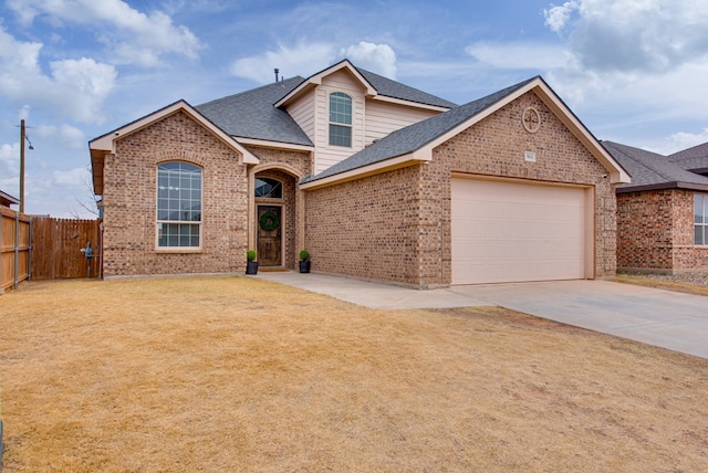 traditional-style house with driveway, an attached garage, fence, a front lawn, and brick siding