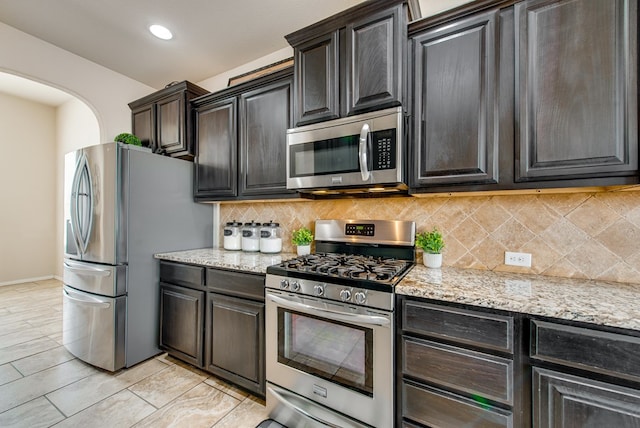 kitchen with light stone countertops, tasteful backsplash, appliances with stainless steel finishes, and a warming drawer