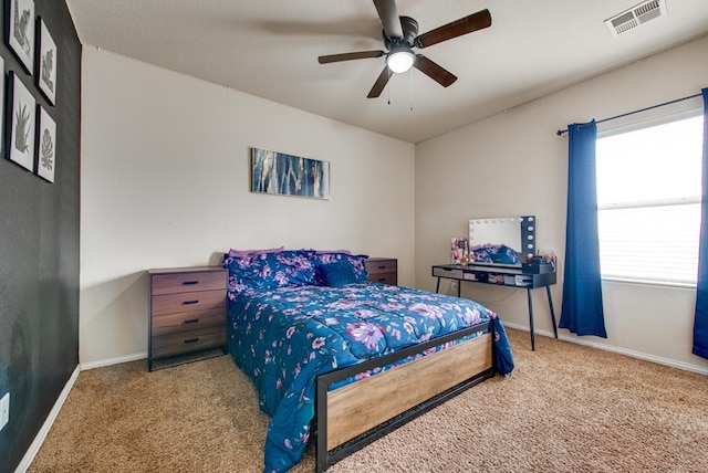 carpeted bedroom featuring ceiling fan, visible vents, and baseboards