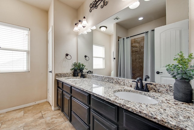 full bathroom with double vanity, a sink, visible vents, and baseboards