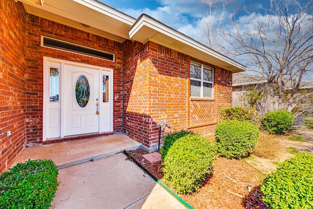 doorway to property featuring brick siding