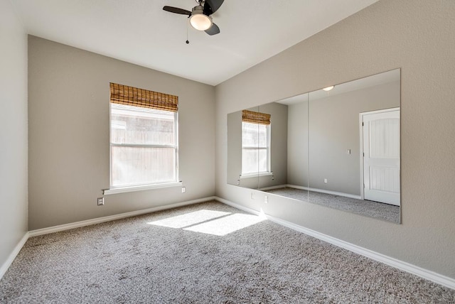 unfurnished room featuring carpet floors, a ceiling fan, and baseboards