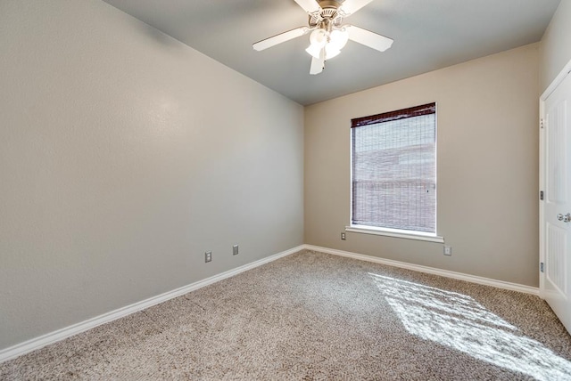 carpeted empty room with ceiling fan and baseboards