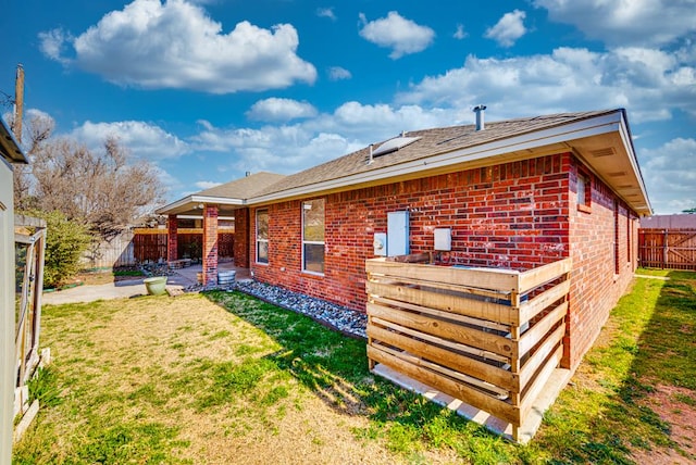 back of property with brick siding and a patio